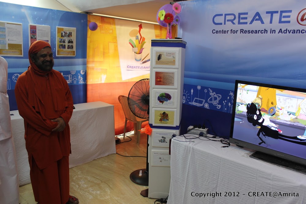 28-Sampoojya Swami Purnamritananda Puri at the CREATE demo booth watching the animation video of the Amala Bharatham Campaign